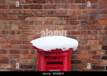 Un tradizionale pilastro rosso box coperto di neve a Worcester, Regno Unito Foto Stock