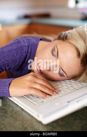 Ragazza dorme sul computer portatile Foto Stock