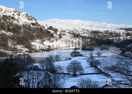 Rydal acqua con neve rivestiti montagne, Cumbria, Regno Unito Foto Stock