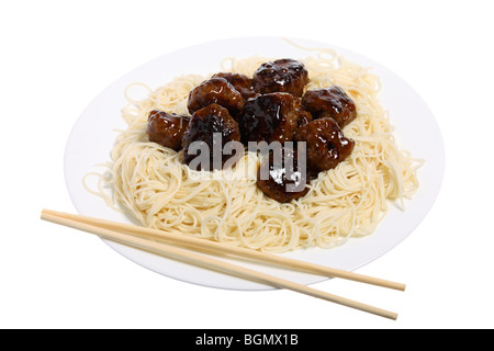 Un pasto a base di polpette di carne in salsa agrodolce con le tagliatelle e bacchette. Foto Stock