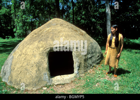 Cherokee tradizionale donna di fronte a una tradizionale casa estiva al Cherokee Museo Nazionale Indiano, Tahlequay Oklahoma Foto Stock