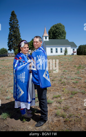 Coppia di novelli sposi al Williamson River Indian chiesa della missione sono avvolti insieme all'interno di un indiano coperta come un simbolo di un basso Foto Stock