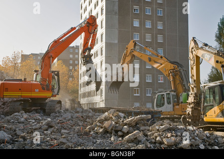 Tre escavatori in azione su un edificio sito di demolizione di HLM edificio, Francia Foto Stock