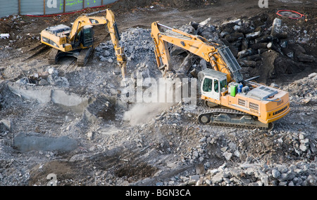 Escavatori cingolati su un edificio cantiere di demolizione Foto Stock