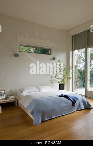 Camera da letto con pavimento in legno in casa contemporanea Foto Stock