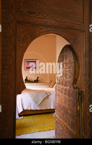 Portale scolpito si apre sulla camera da letto di un riad nella Medina di Marrakech Foto Stock