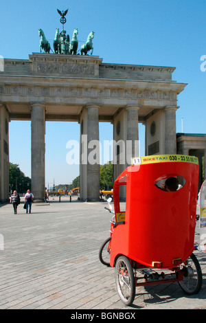 Red Velotaxi bici / risciò ciclo davanti alla Porta di Brandeburgo / Brandenburger Tor a Berlino, Germania Foto Stock