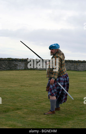 Un uomo in costume storico re-decreta battaglie storiche al Sinclair raccolta, Noss, vicino a Wick, Scozia. Foto Stock