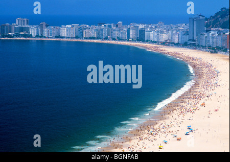 Sopra la spiaggia di Ipanema a Rio de Janerio con la gente a prendere il sole sulla spiaggia di sabbia bianca tra la linea delle onde e gli alberghi Foto Stock