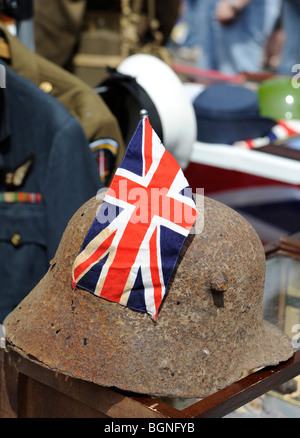 Un corroso la Seconda Guerra Mondiale la fanteria tedesca casco presenta un flag di unione inseriti in un memorabilia in stallo durante il carnevale. Foto Stock