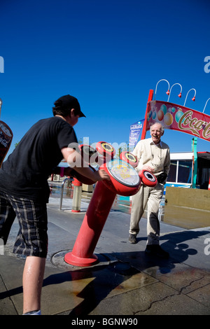 Uomo anziano ridere del giovane ragazzo di bagnare a coke immergere la macchina Universal Studios Hollywood Los Angeles, Stati Uniti. Foto Stock