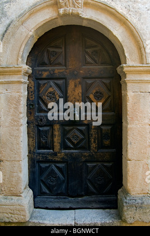 Vecchio scolpita in legno porta in vicolo del borgo medievale, Banon Alpes-de-Haute-Provence, Provenza, Francia Foto Stock