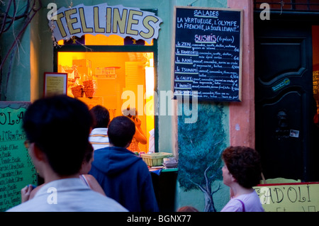 Arles, Francia, piccoli gruppi di persone che arrivano da dietro, accanto alla finestra del ristorante fast food da asporto, in strada, Foto Stock