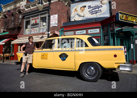 Tourist da un giallo taxi in una Brooklyn street scene, gli Universal Studios Hollywood Los Angeles California USA Foto Stock