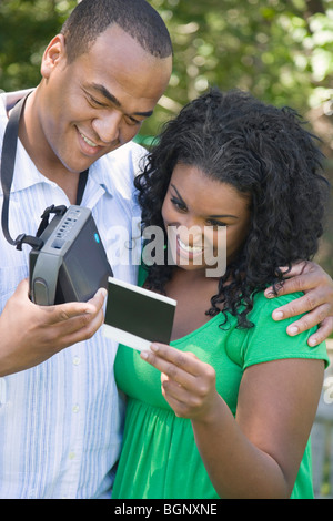 Close-up di una giovane donna e una metà uomo adulto guardando una fotografia Foto Stock