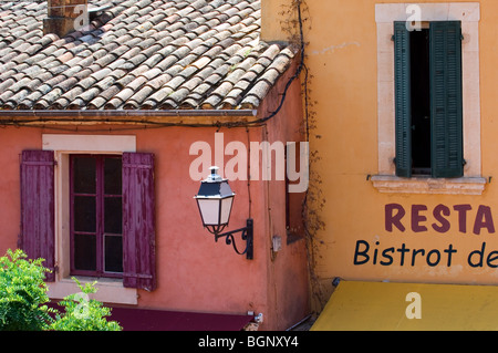 Facciate colorate di case con tendine e schede del Louvre, Roussillon, Provenza, Vaucluse, Provence-Alpes-Côte d'Azur, in Francia Foto Stock