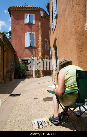 Pittore il disegno di colore ocra facciate di case con tendine in vicolo, Roussillon, Provenza, Vaucluse Francia Foto Stock