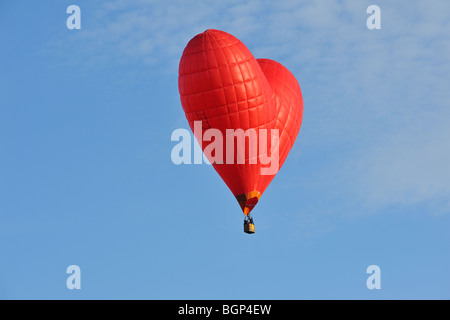 Balloonists / Aeronauts battenti in rosso a forma di cuore ad aria calda a palloncino durante la mongolfiera sale riunioni Foto Stock