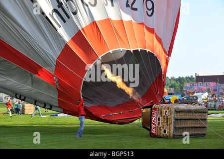 Aria calda / balloonists Aeronauts preparazione e il gonfiaggio della mongolfiera con propano bruciatori durante la mongolfiera incontro, Belgio Foto Stock