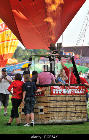 Aria calda / balloonists Aeronauts preparazione e il gonfiaggio della mongolfiera con propano bruciatori durante la mongolfiera incontro, Belgio Foto Stock