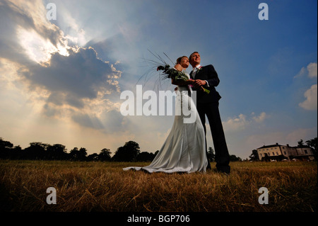 Gli sposi abbracciare ogni altra sui prati del Newick Park Hotel in East Sussex. Foto da Jim Holden. Foto Stock