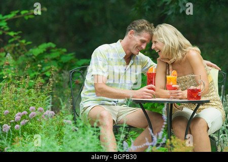 Coppia matura azienda bicchieri di succo e sorridente Foto Stock