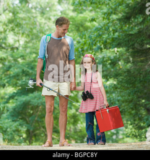 Uomo maturo in piedi con la mano della figlia Foto Stock