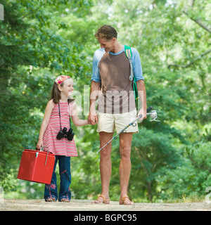 Uomo maturo in piedi con la mano della figlia Foto Stock