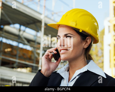 Ingegnere femmina parlando al telefono mobile nel sito in costruzione Foto Stock