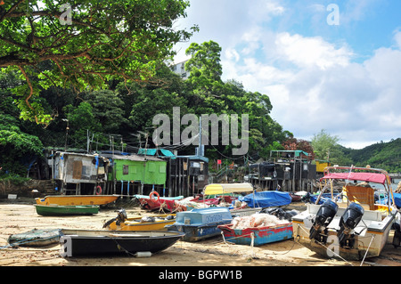 Il canottaggio e motorizzato da barche da pesca nella parte anteriore dei pescatori stilt informale delle abitazioni, Yung Shue Wan, Lamma, Isola di Hong Kong Foto Stock