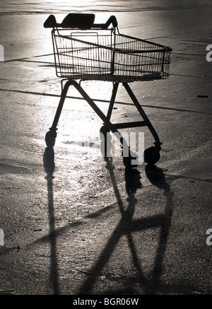 Un vuoto Carrello spesa stagliano su un parcheggio auto. Foto Stock