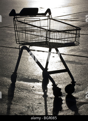 Un vuoto Carrello spesa stagliano su un parcheggio auto. Foto Stock