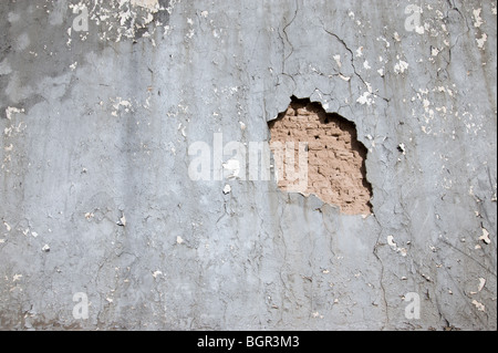 Un vecchio muro in stucco si sbriciola lontano, rivelando una vecchia adobe un muro di mattoni al di sotto, in Carrizozo, Nuovo Messico. Foto Stock
