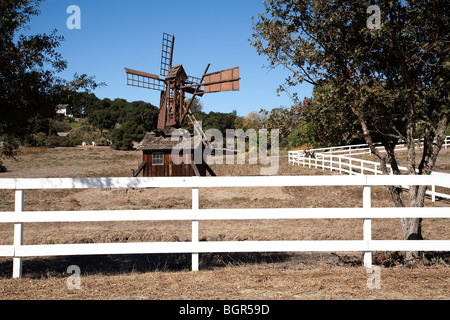 Un vecchio mulino a vento in legno si siede dietro un bianco cancellata nella Santa Ynez Valley di Santa Barbara County, California. Foto Stock