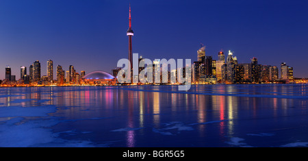 Panorama di ghiaccio congelato coperto lago Ontario riflette le luci della città di Toronto skyline al tramonto in inverno Foto Stock