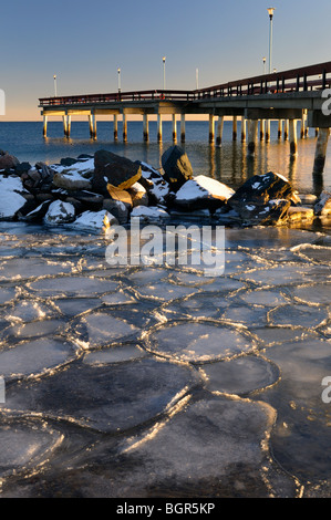 Tramonto al centro di Toronto Island Pier in inverno con ghiaccio scorre a mosaico e pilone riflessioni sul lago Ontario Foto Stock