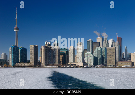 Riattivazione di un inverno di traghetti per le isole di Toronto mantenendo un canale aperto su una coperta di ghiaccio del lago Ontario con lo skyline della città e granita di ghiaccio Foto Stock