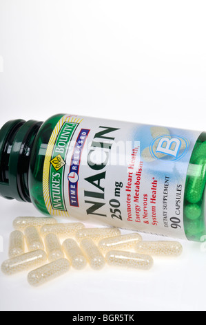 Una bottiglia di niacina integratori dietetici posa sul suo lato con alcune capsule sparse su sfondo bianco, ritaglio. Foto Stock