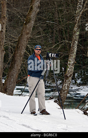 Fotografo scatta le foto sulla coperta di neve banca del fiume Tellico in Cherokee National Forest in Tennessee Foto Stock