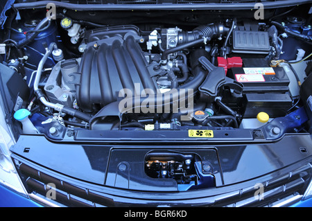 Sotto il cofano motore in prossimità di un blu Nota Nissan berlina autovettura che mostra un motore a benzina vano England Regno Unito Foto Stock