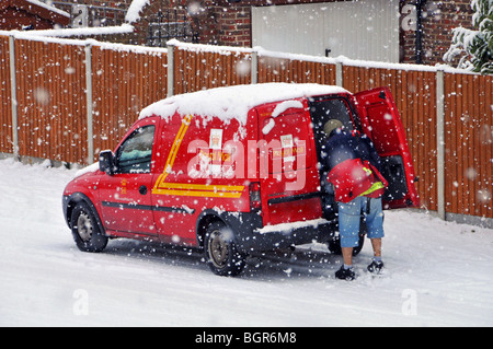 Freddo inverno nevica su Royal Mail consegna postman lavoro da postfurgone in scena residenziale di strada in tempesta di neve Brentwood Essex Inghilterra Regno Unito Foto Stock