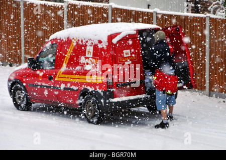 Inverno freddo scena nevicando sulla posta reale consegna postman lavoro da post van in strada residenziale in tempesta di neve Brentwood Essex Inghilterra Regno Unito Foto Stock