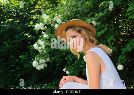 Giovane donna di riposo in giardino Foto Stock