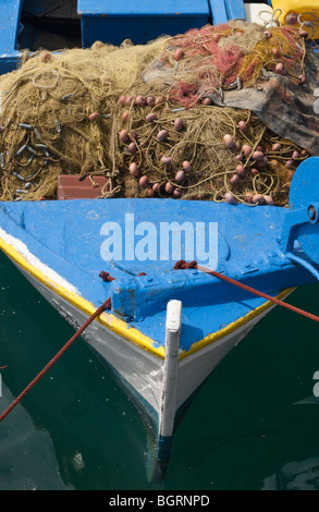 Il blue prua di una piccola in legno barca da pesca con reti sul ponte, legato al molo a Poros Town, Grecia Foto Stock