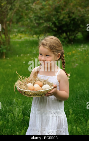 Bambina tenendo le uova Foto Stock