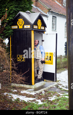 L'uomo facendo una telefonata all'interno di un vecchio rari AA casella Telefono, Garrowby vicino a York Dic 2009. Foto Stock