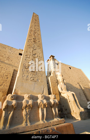 LUXOR, Egitto. L'obelisco al Tempio di Luxor, con pilone e Colossi di Ramses II dietro. Foto Stock