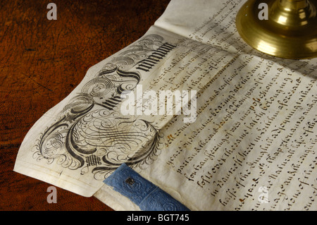 Un indenture, c. 1718, scritto in inglese e un candelabro di ottone, su una pelle sormontato scrivania Foto Stock