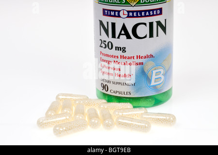 Una bottiglia di niacina integratori dietetici con alcune capsule sparse fuori della bottiglia su sfondo bianco, ritaglio. Foto Stock