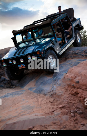 Hummer guida fuori strada che scende ripida pendenza di slickrock vicino a Moab, Utah, Stati Uniti d'America Foto Stock